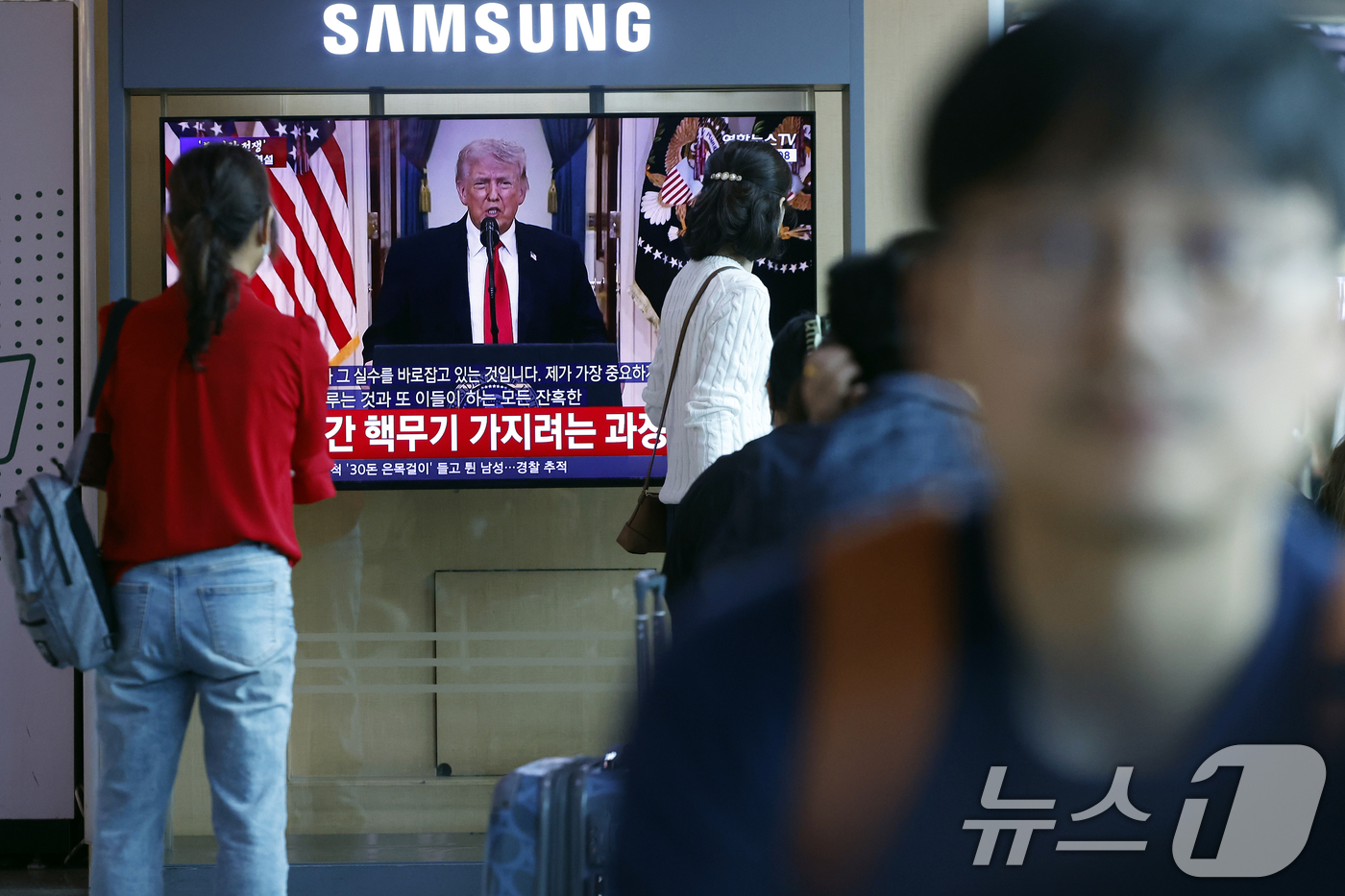 (서울=뉴스1) 박정호 기자 = 2일 오전 서울시 용산구 서울역 대합실에서 시민들이 도널드 트럼프 미국 대통령의 이란 전쟁 상황 관련 대국민 연설 TV 생중계를 지켜보고 있다. …