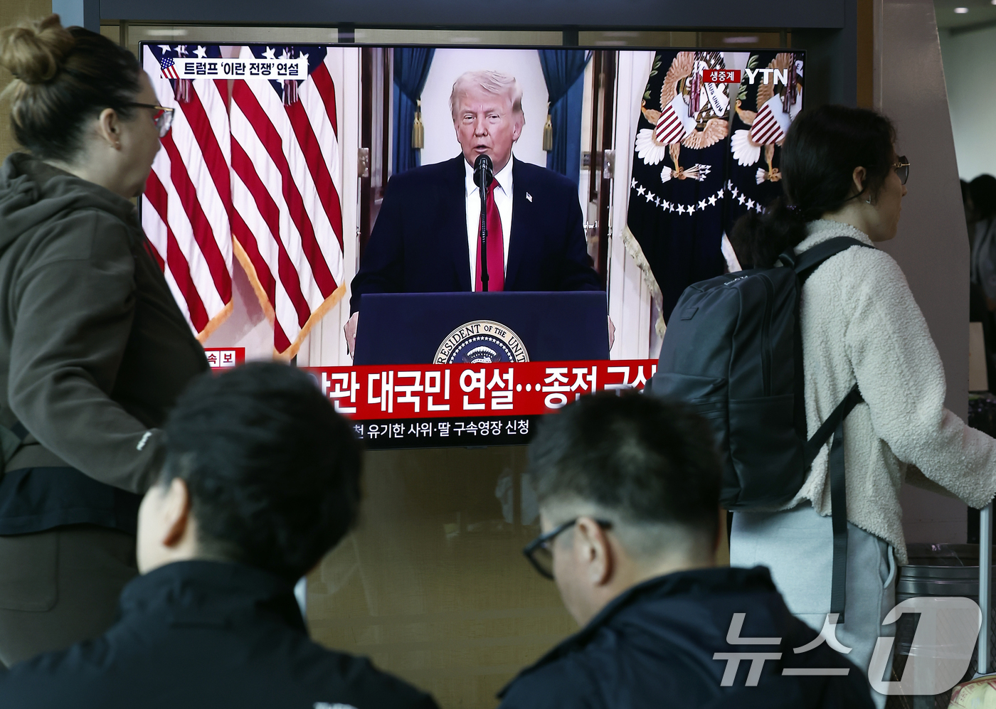 (서울=뉴스1) 박정호 기자 = 2일 오전 서울시 용산구 서울역 대합실에서 외국인 관광객과 시민들이 도널드 트럼프 미국 대통령의 이란 전쟁 상황 관련 대국민 연설 TV 생중계를 지 …