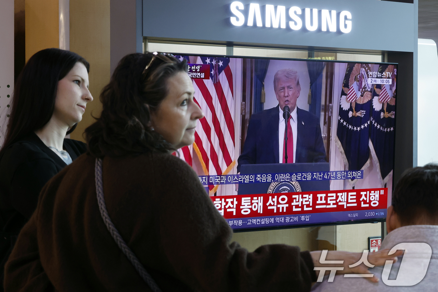 (서울=뉴스1) 박정호 기자 = 2일 오전 서울시 용산구 서울역 대합실에서 외국인 관광객들이 도널드 트럼프 미국 대통령의 이란 전쟁 상황 관련 대국민 연설 TV 생중계를 지켜보고 …