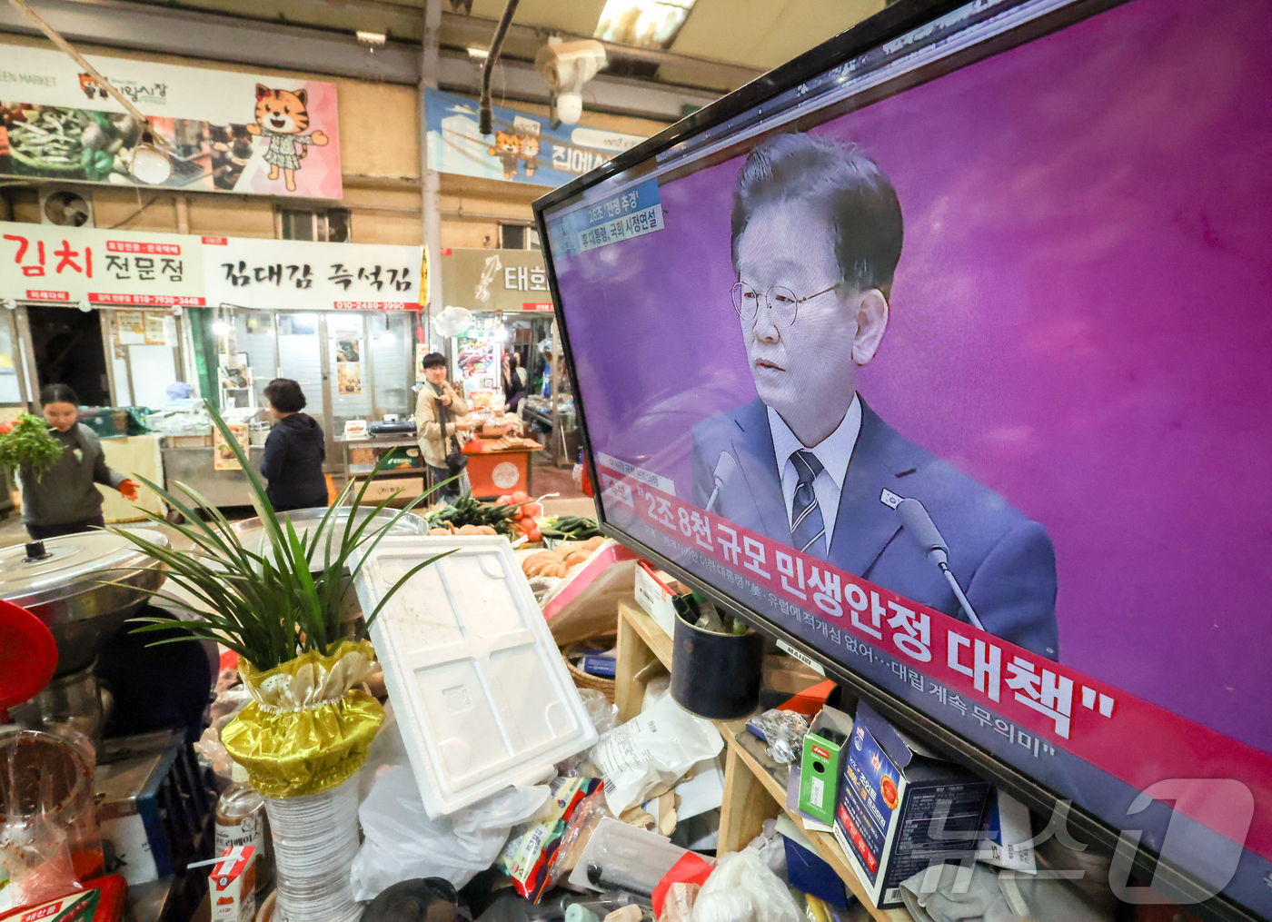 (서울=뉴스1) 이종수 인턴기자 = 26조2000억 원 규모 추가경정예산안에 민생회복 소비쿠폰 지급이 포함된 가운데 2일 서울 시내 한 전통시장에 이재명 대통령의 시정 연설이 TV …