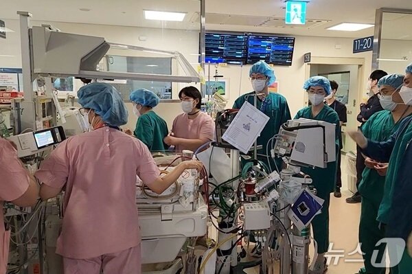 본문 이미지 - 한결이가 10명이 넘는 의료진과 함께 수술장으로 이동하는 모습. (병원 제공)