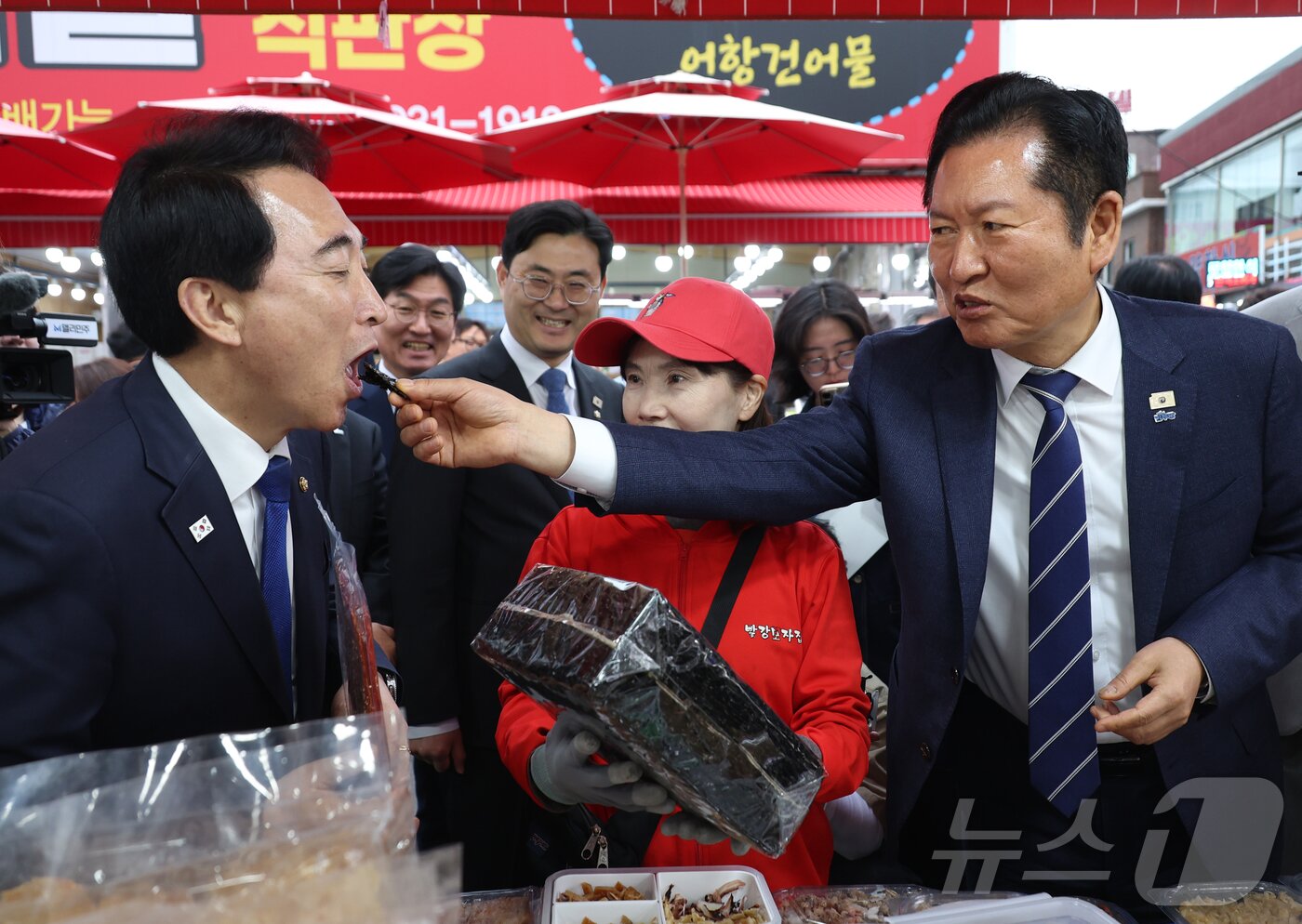 본문 이미지 - 정청래 더불어민주당 대표가 20일 충남 대천항수산시장에서 박수현 충남도지사 후보에게 김을 먹여주고 있다. 2026.4.20 ⓒ 뉴스1 김기태 기자