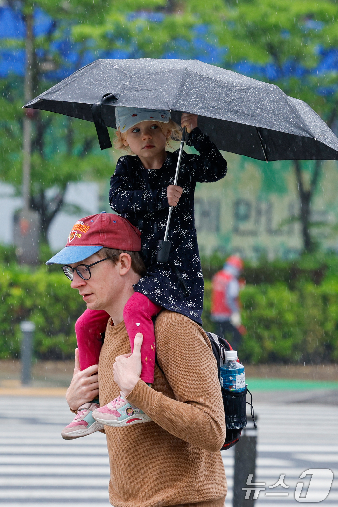 (서울=뉴스1) 안은나 기자 = 절기상 '곡우'(穀雨, 백곡을 기름지게 하는 봄비가 내림)인 20일 서울 중구 세종대로에서 우산을 쓴 외국인 어린이가 목마를 타고 있다. 2026. …