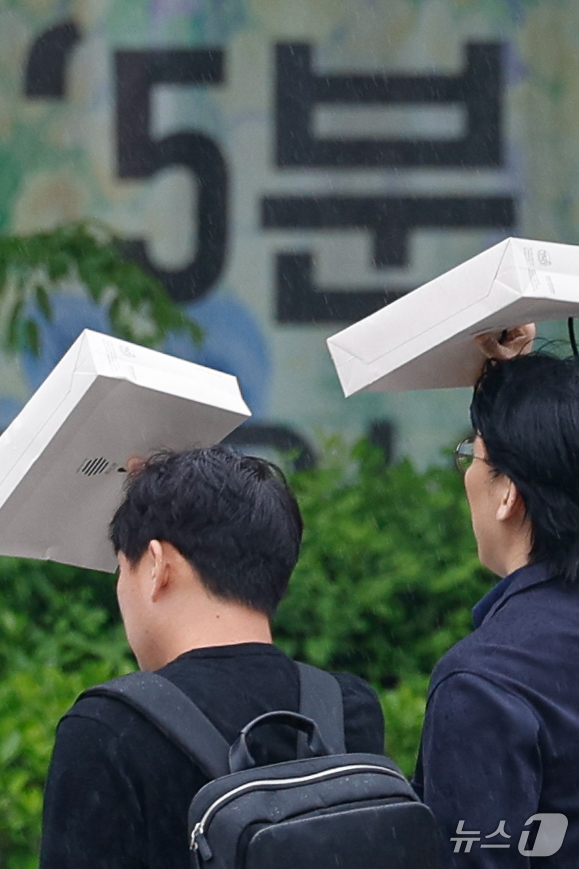 (서울=뉴스1) 안은나 기자 = 절기상 '곡우'(穀雨, 백곡을 기름지게 하는 봄비가 내림)인 20일 서울 중구 세종대로에서 우산 대신 봉투를 쓴 시민들이 지나가고 있다. 2026. …