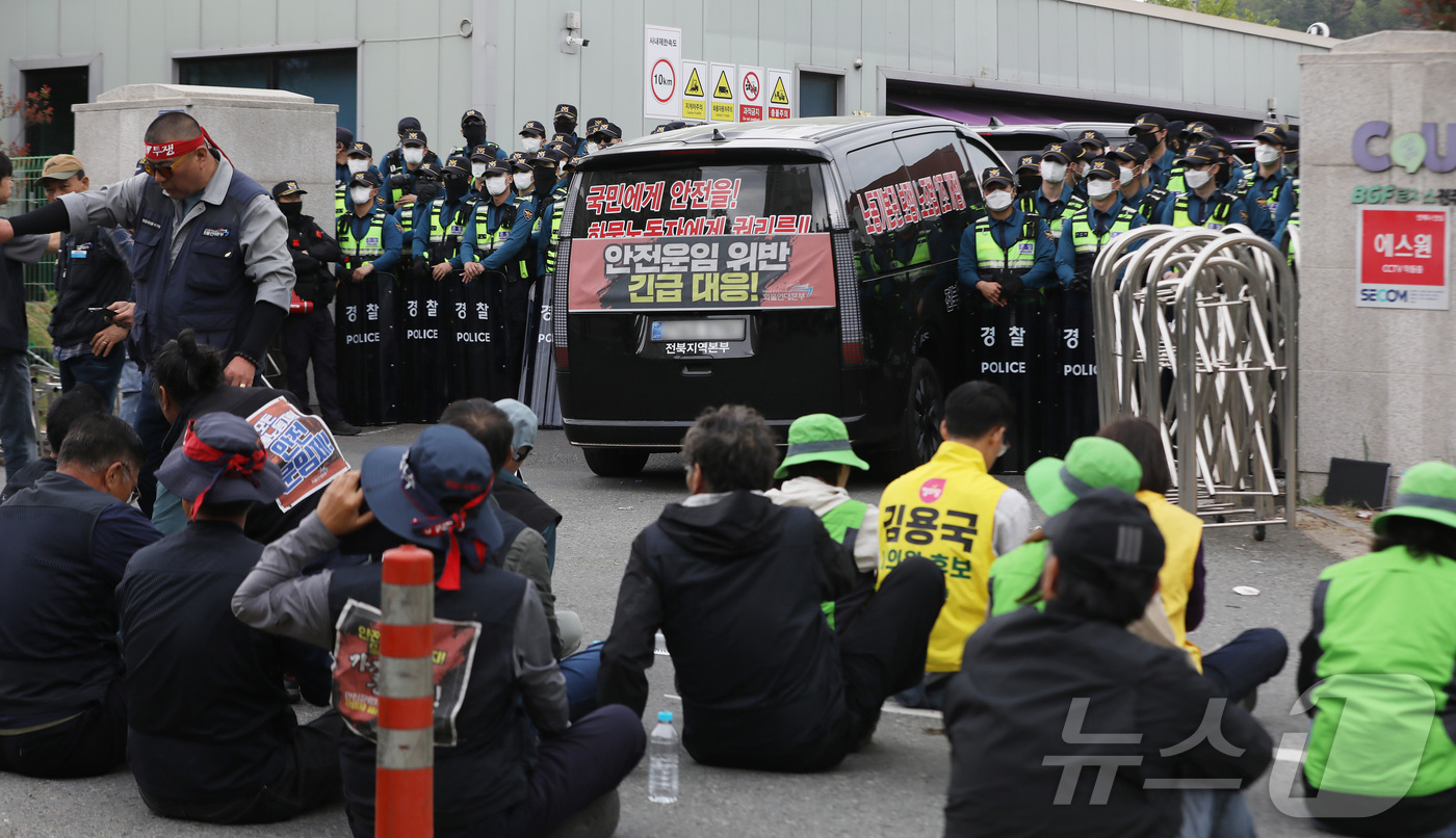 (진주=뉴스1) 윤일지 기자 = 20일 경남 진주시 정촌면 CU 진주물류센터 앞에서 경찰이 민주노총 화물연대 CU지회 노조원들을 막아 서고 있다. 물류센터 정문 앞에는 진입을 시도 …