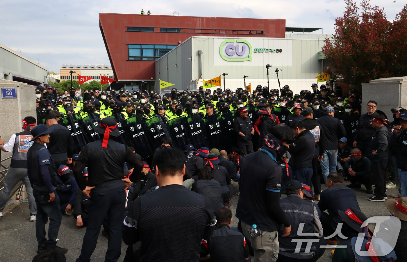 (진주=뉴스1) 윤일지 기자 = 20일 경남 진주시 정촌면 CU 진주물류센터 앞에서 진입을 시도하는 화물연대 노조원들을 경찰이 막아서고 있다.이날 현장에서는 화물차와 집회 참가자 …