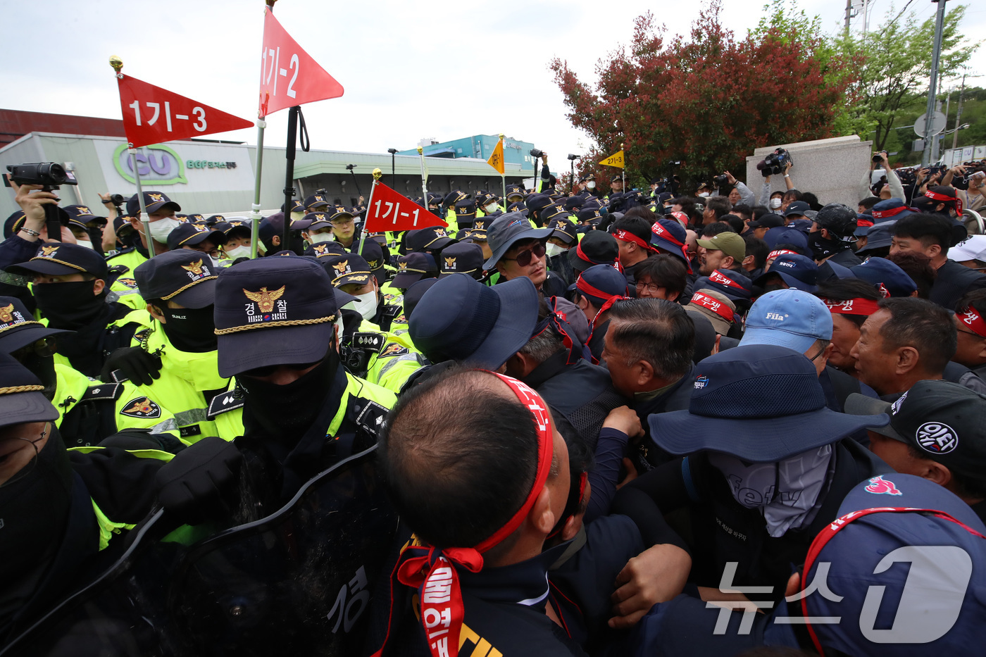 (진주=뉴스1) 윤일지 기자 = 20일 경남 진주시 정촌면 CU 진주물류센터 앞에서 진입을 시도하는 화물연대 노조원들을 경찰이 막아서고 있다.이날 현장에서는 화물차와 집회 참가자 …