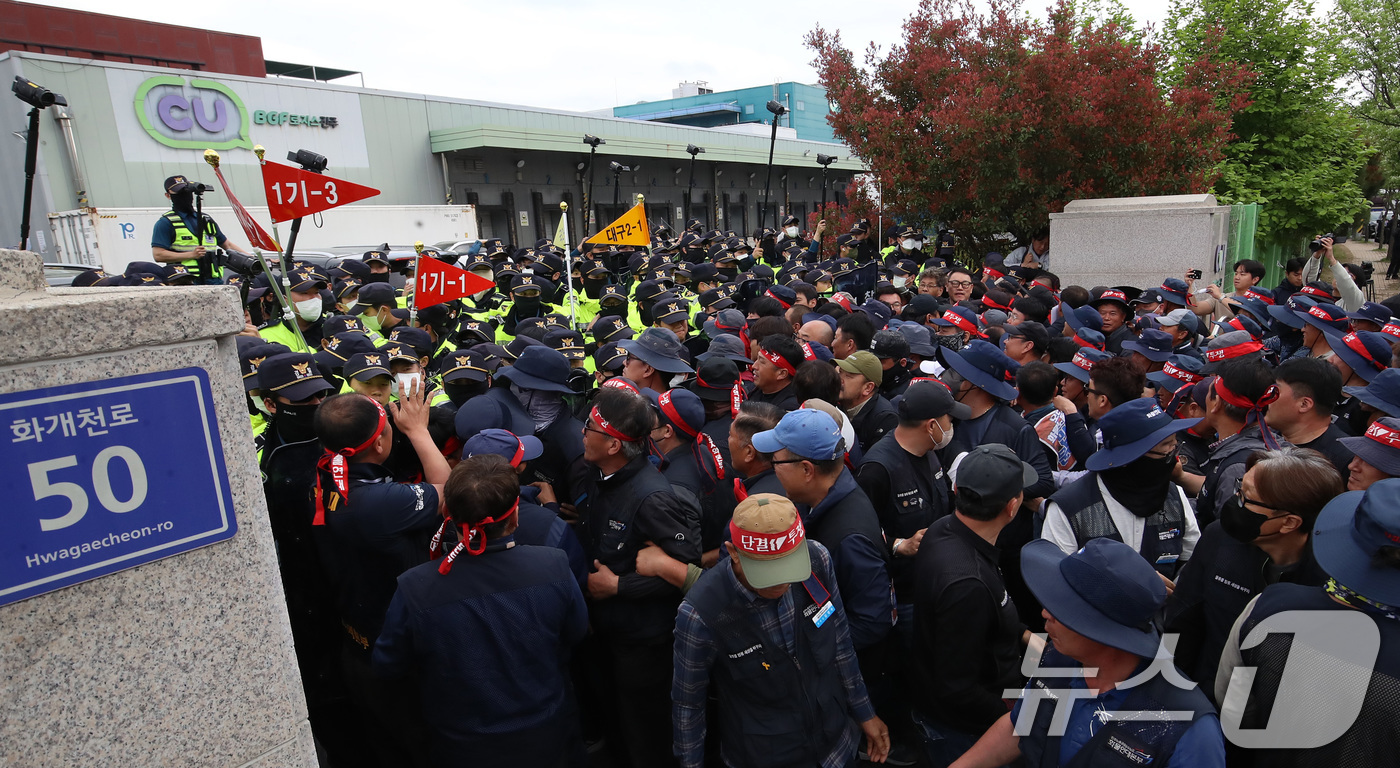 (진주=뉴스1) 윤일지 기자 = 20일 경남 진주시 정촌면 CU 진주물류센터 앞에서 진입을 시도하는 화물연대 노조원들을 경찰이 막아서고 있다.이날 현장에서는 화물차와 집회 참가자 …