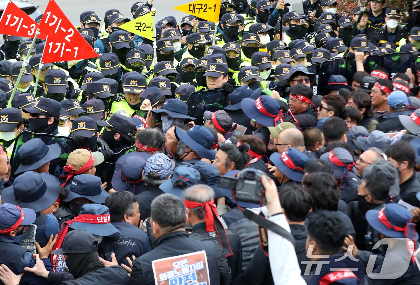 본문 이미지 - 20일 경남 진주시 정촌면 CU 진주물류센터 앞에서 진입을 시도하는 화물연대 노조원들을 경찰이 막아서고 있다. 이날 현장에서는 화물차와 집회 참가자 3명이 충돌해 1명이 숨지고 2명이 다치는 사고가 발생했다. 2026.4.20 ⓒ 뉴스1 윤일지 기자