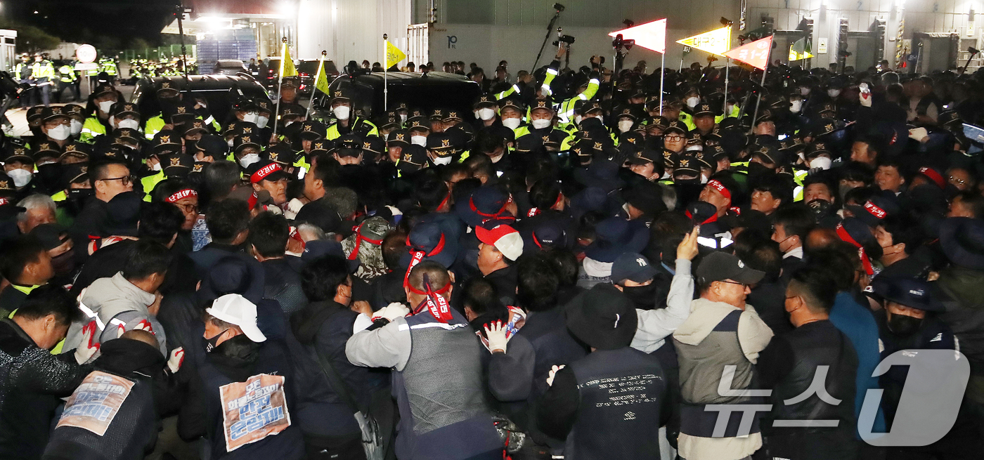 (진주=뉴스1) 윤일지 기자 = 20일 경남 진주시 정촌면 CU 진주물류센터 앞에서 진입을 시도하는 화물연대 노조원들을 경찰이 막아서고 있다.이날 현장에서는 화물차와 집회 참가자 …