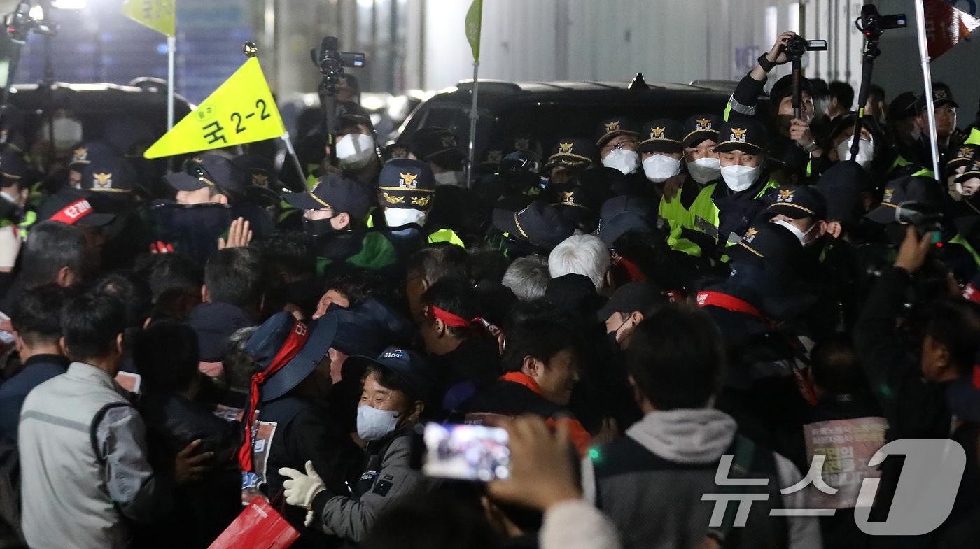 (진주=뉴스1) 윤일지 기자 = 20일 경남 진주시 정촌면 CU 진주물류센터 앞에서 진입을 시도하는 화물연대 노조원들을 경찰이 막아서고 있다.이날 현장에서는 화물차와 집회 참가자 …