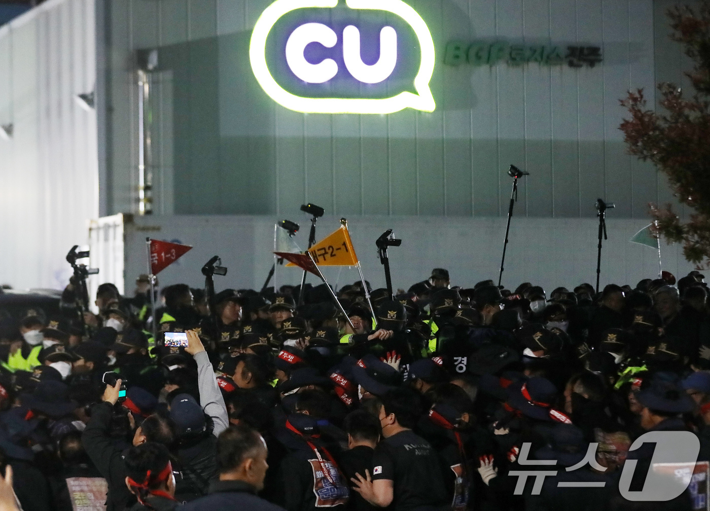 (진주=뉴스1) 윤일지 기자 = 20일 경남 진주시 정촌면 CU 진주물류센터 앞에서 진입을 시도하는 화물연대 노조원들을 경찰이 막아서고 있다.이날 현장에서는 화물차와 집회 참가자 …