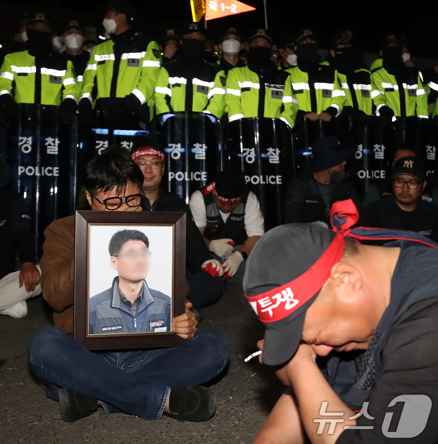 (진주=뉴스1) 윤일지 기자 = 20일 경남 진주시 정촌면 CU 진주물류센터 앞에서 화물연대 노조원이 집회 중 2.5톤 화물차에 치어 숨진 노조원의 영정을 들고 슬픔에 잠겨 있다. …