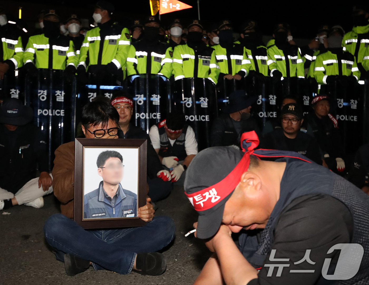 (진주=뉴스1) 윤일지 기자 = 20일 경남 진주시 정촌면 CU 진주물류센터 앞에서 화물연대 노조원이 집회 중 2.5톤 화물차에 치어 숨진 노조원의 영정을 들고 슬픔에 잠겨 있다. …