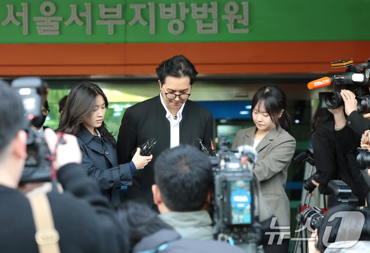 본문 이미지 - ‘부실 복무’ 혐의를 받는 송민호가 21일 서울 마포구 서울서부지방법원에서 열린 1차 공판을 마친 뒤 준비된 차량으로 이동하고 있다. 2026.4.21 ⓒ 뉴스1 권현진 기자