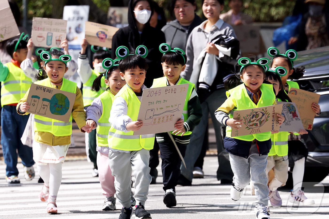 (광주=뉴스1) 박지현 기자 = 지구의 날을 하루 앞둔 21일 광주 북구청직장어린이집 아이들과 구청 기후환경과 직원들이 북구청 교차로에서 일회용품 사용 자제와 탄소중립 손팻말을 들 …