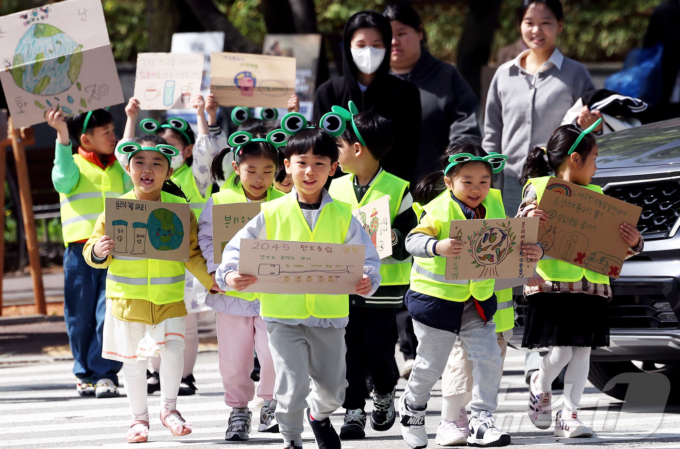 (광주=뉴스1) 박지현 기자 = 지구의 날을 하루 앞둔 21일 광주 북구청직장어린이집 아이들과 구청 기후환경과 직원들이 북구청 교차로에서 일회용품 사용 자제와 탄소중립 손팻말을 들 …