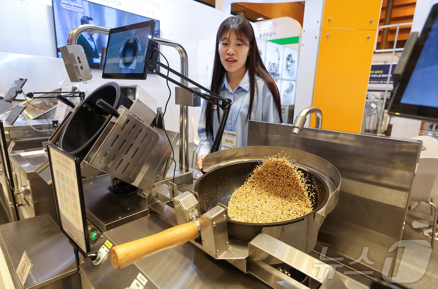 (서울=뉴스1) 김성진 기자 = 21일 서울 강남구 코엑스에서 열린 2026 우수급식외식산업전에서 한 관계자가 자동화 웍에 대해 설명하고 있다. 2026.4.21/뉴스1
