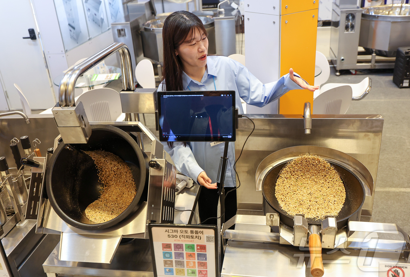 (서울=뉴스1) 김성진 기자 = 21일 서울 강남구 코엑스에서 열린 2026 우수급식외식산업전에서 한 관계자가 자동화 웍에 대해 설명하고 있다. 2026.4.21/뉴스1