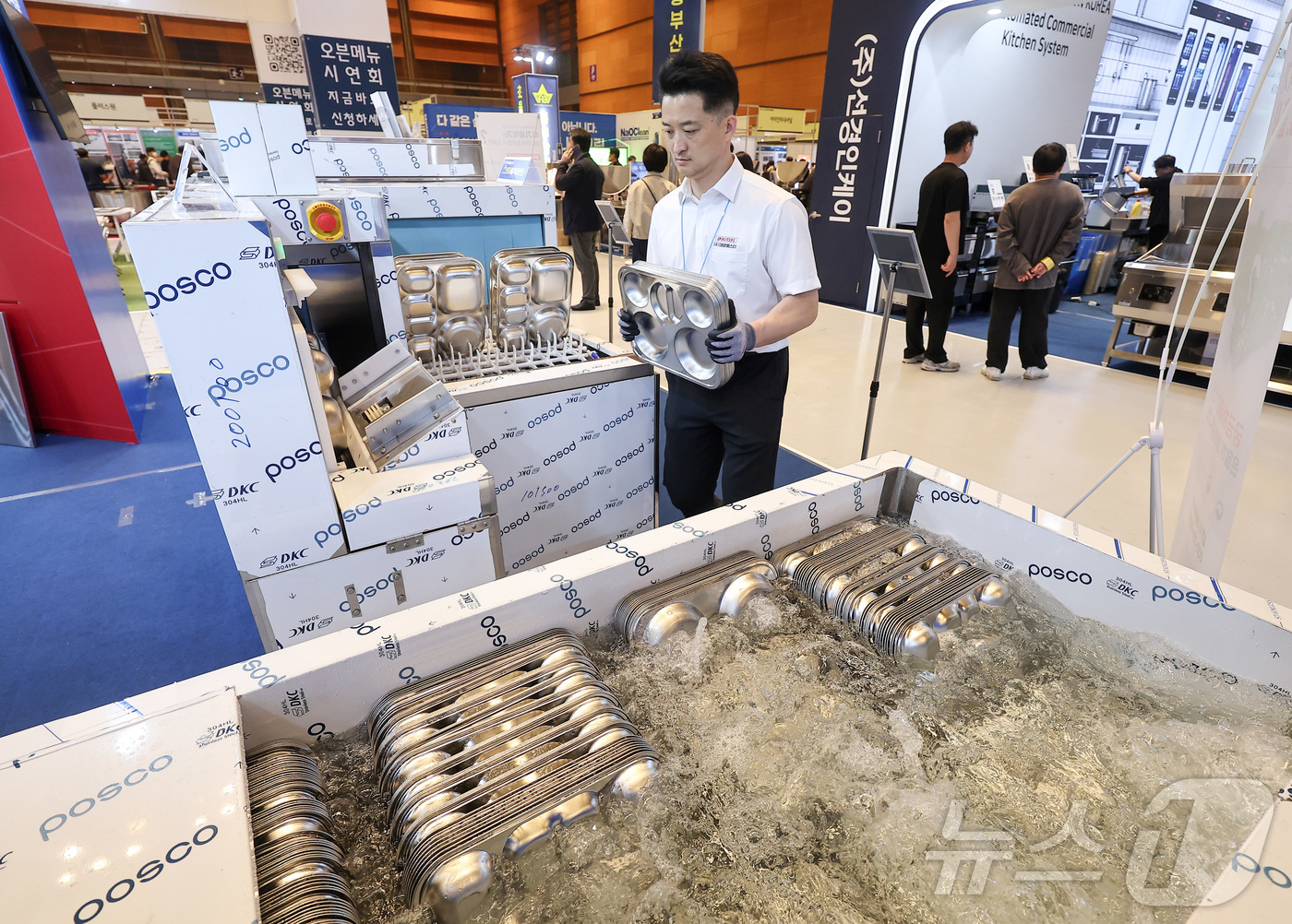 (서울=뉴스1) 김성진 기자 = 21일 서울 강남구 코엑스에서 열린 2026 우수급식외식산업전에서 한 관계자가 식판 스마트 세척기 시연을 선보이고 있다. 2026.4.21/뉴스1