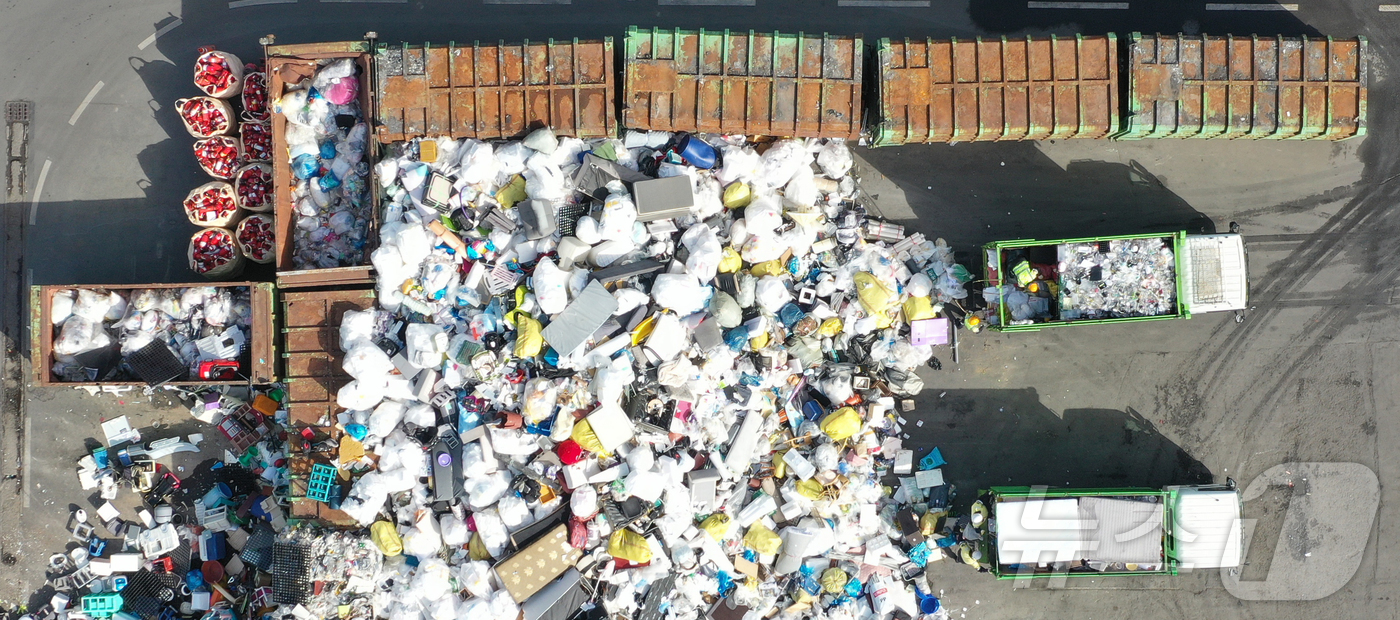 (수원=뉴스1) 김영운 기자 = '지구의 날'을 하루 앞둔 21일 경기 수원시 영통구 수원시자원순환센터에서 관계자들이 재활용 쓰레기를 처리하고 있다.