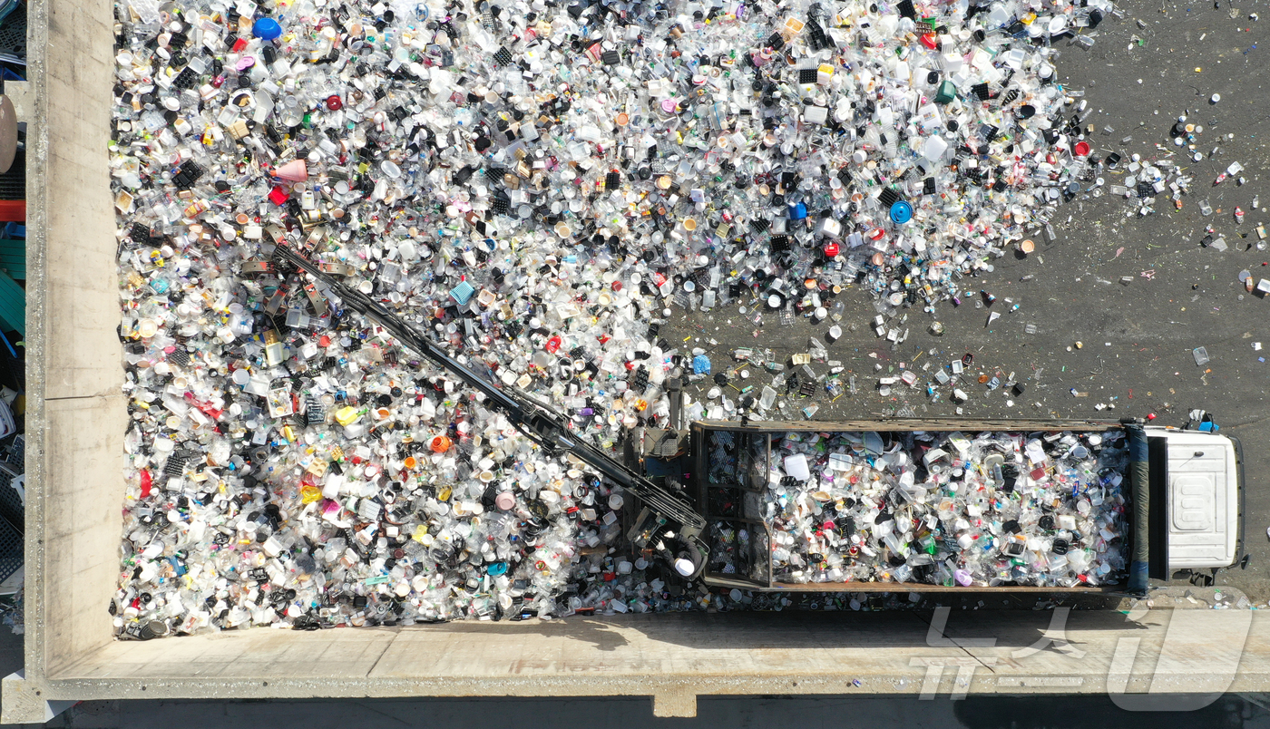 (수원=뉴스1) 김영운 기자 = '지구의 날'을 하루 앞둔 21일 경기 수원시 영통구 수원시자원순환센터에서 관계자들이 재활용 쓰레기를 처리하고 있다.