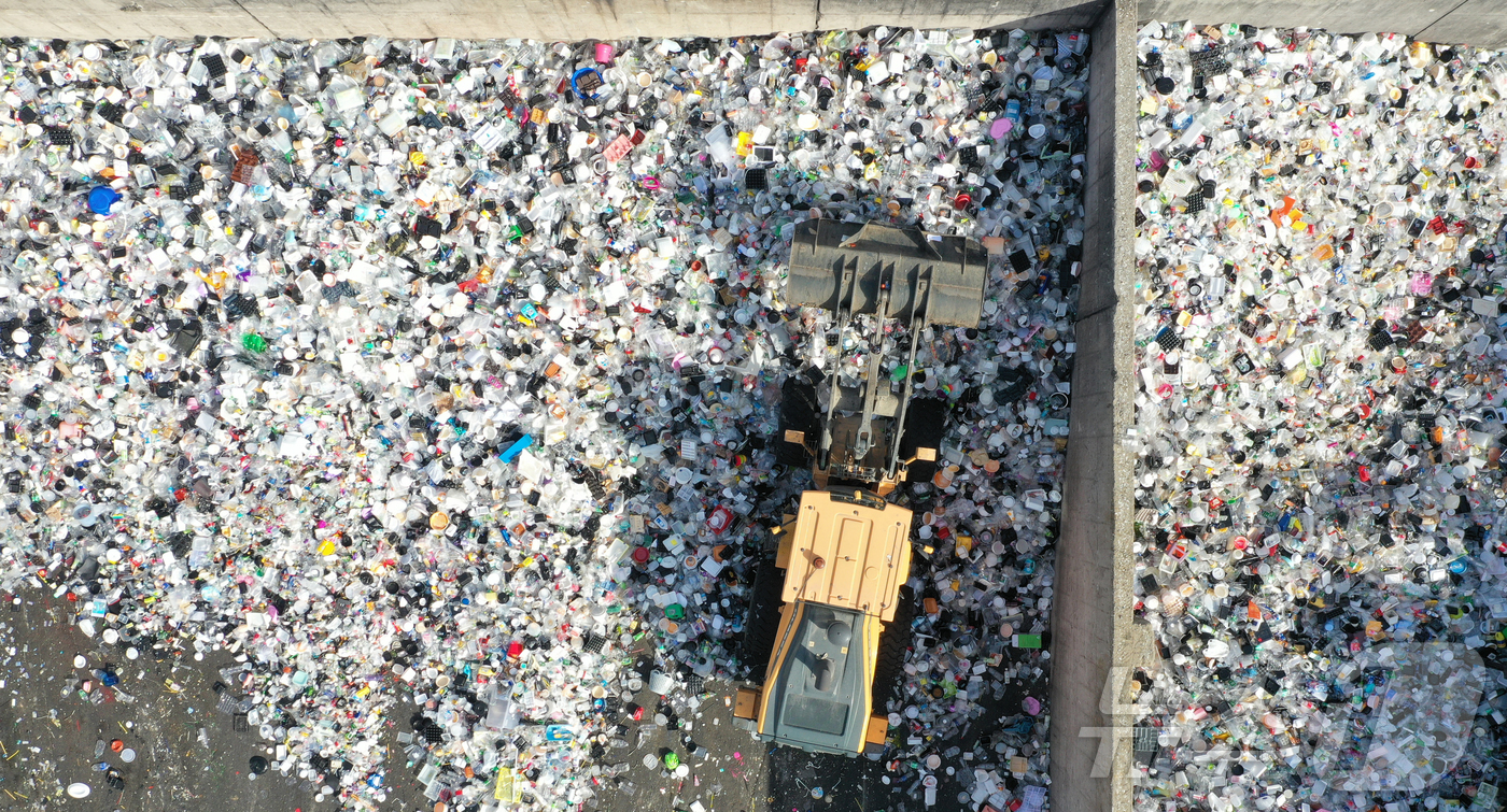 (수원=뉴스1) 김영운 기자 = '지구의 날'을 하루 앞둔 21일 경기 수원시 영통구 수원시자원순환센터에서 관계자들이 재활용 쓰레기를 처리하고 있다.