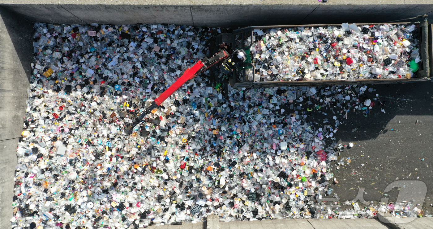 (수원=뉴스1) 김영운 기자 = '지구의 날'을 하루 앞둔 21일 경기 수원시 영통구 수원시자원순환센터에서 관계자들이 재활용 쓰레기를 처리하고 있다.