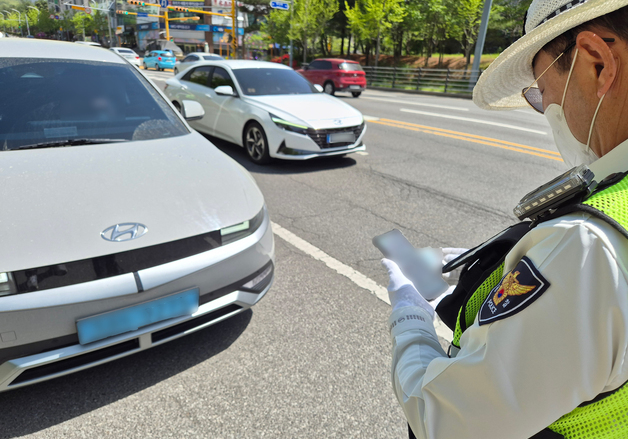 빨간불 우회전 위반으로 범칙금 처분하는 교통 경찰