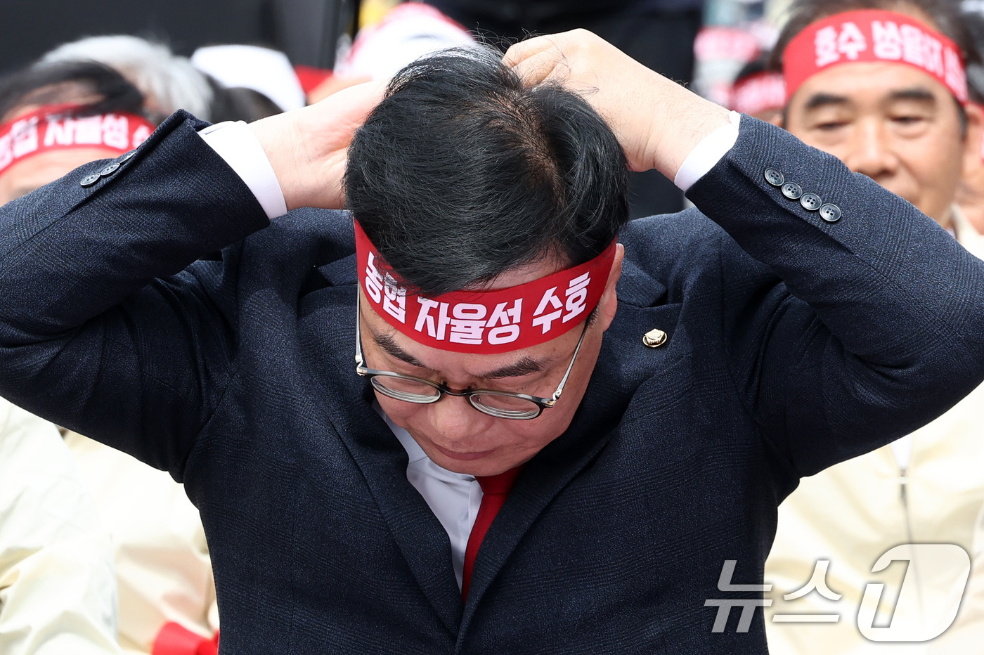 (서울=뉴스1) 최지환 기자 = 송언석 국민의힘 원내대표가 21일 오후 서울 영등포구 여의대로 일대에서 열린 농협 자율성 수호 농민 결의대회에 참석해 머리띠를 묶고 있다. 2026 …