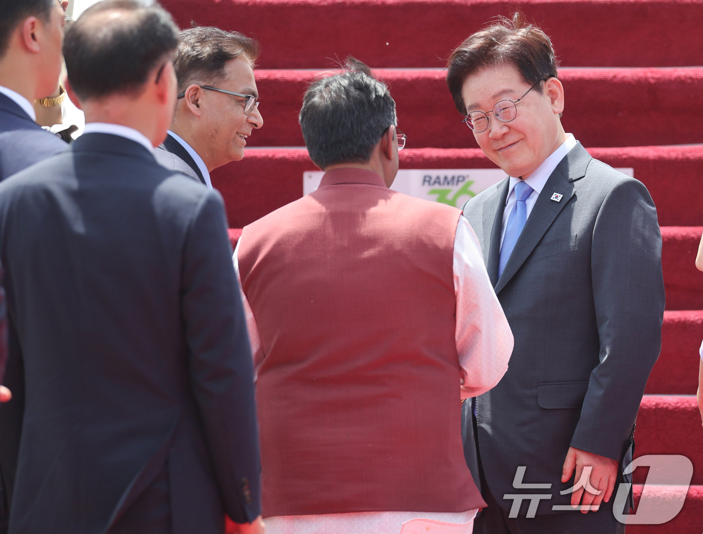 (뉴델리(인도)=뉴스1) 이재명 기자 = 인도 국빈 방문을 마친 이재명 대통령이 21일(현지시간) 뉴델리 팔람 군비행장에서 베트남행 공군 1호기 탑승 전 환송 인사들과 인사하고 있 …