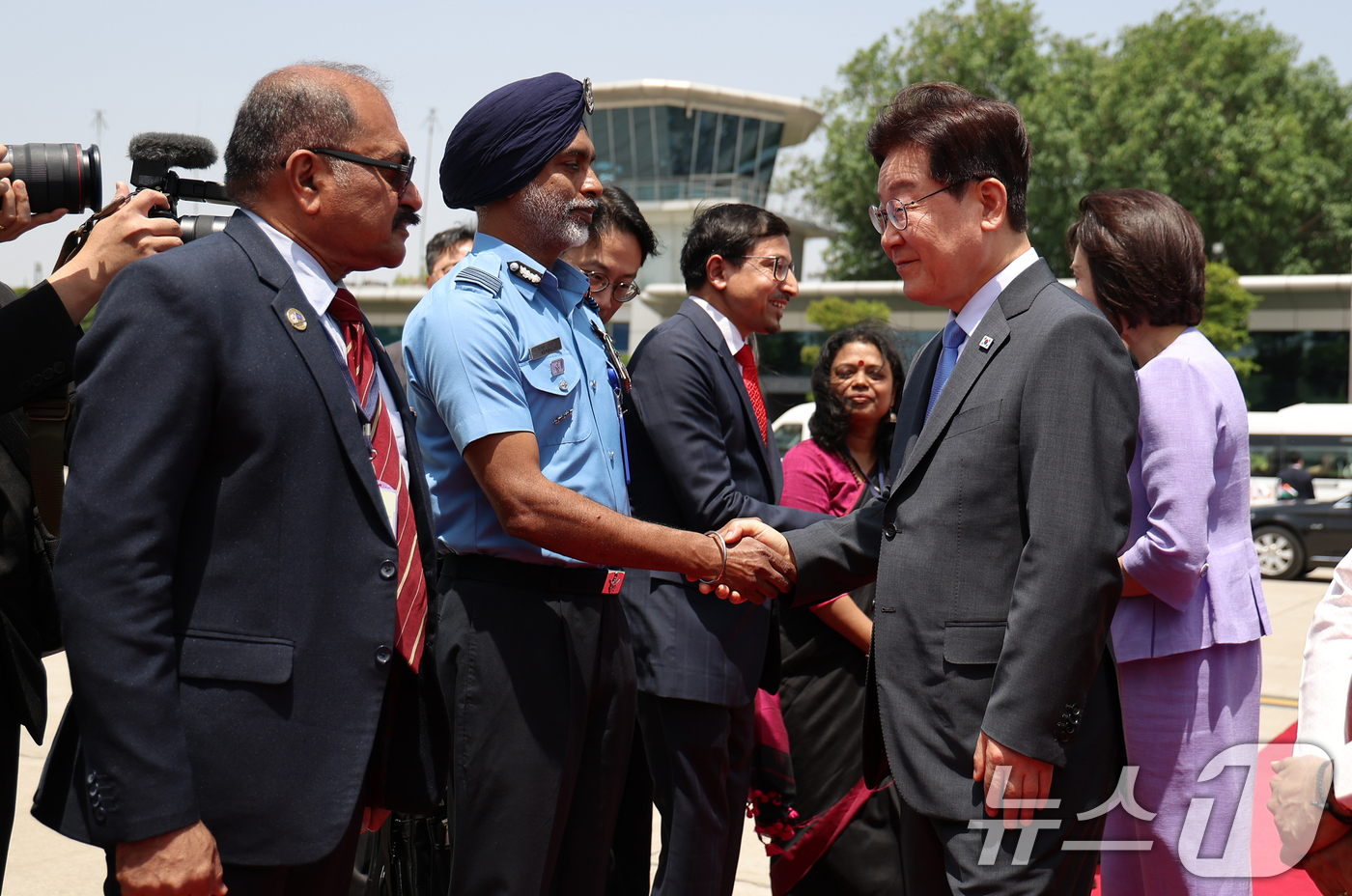 (뉴델리(인도)=뉴스1) 이재명 기자 = 인도 국빈 방문을 마친 이재명 대통령과 김혜경 여사가 21일(현지시간) 뉴델리 팔람 군비행장에서 베트남행 공군 1호기 탑승 전 환송 인사들 …