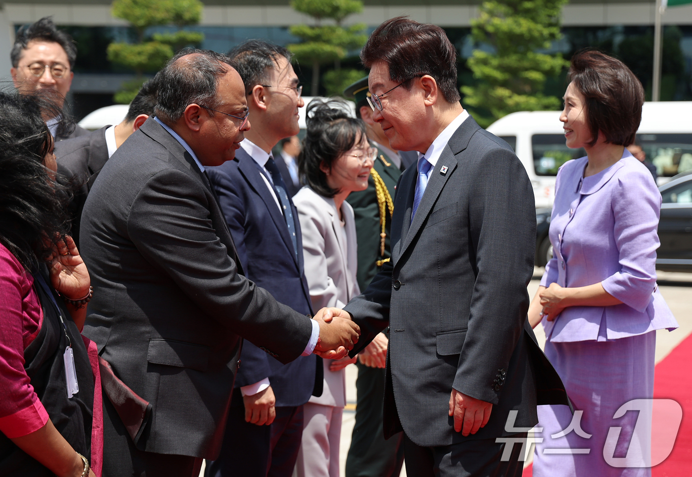(뉴델리(인도)=뉴스1) 이재명 기자 = 인도 국빈 방문을 마친 이재명 대통령과 김혜경 여사가 21일(현지시간) 뉴델리 팔람 군비행장에서 베트남행 공군 1호기 탑승 전 환송 인사들 …