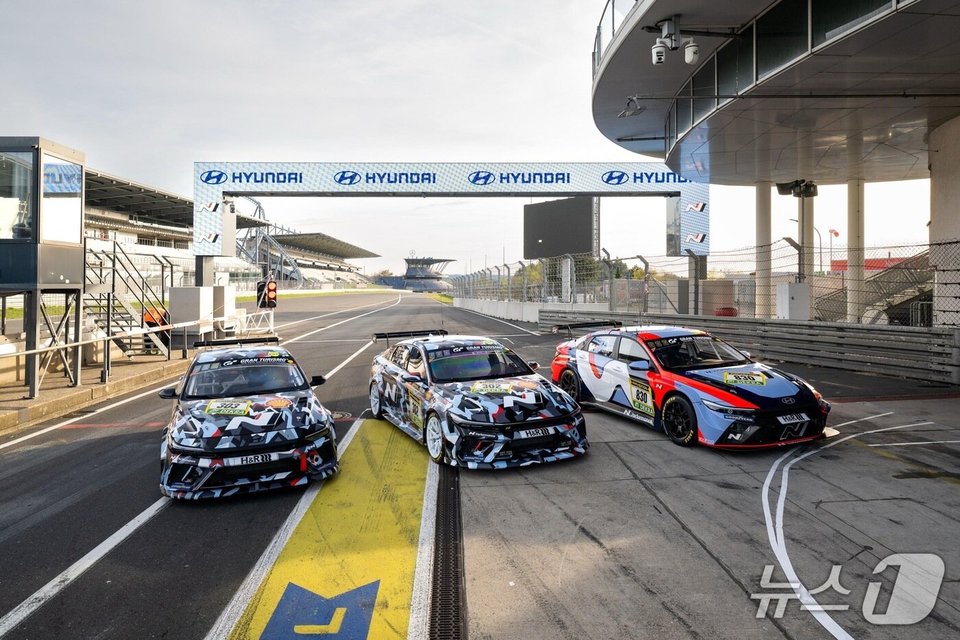 본문 이미지 - 내달 14일(현지시각)부터 17일까지 독일에서 열리는 자동차 내구 레이스 대회 '2026 뉘르부르크링 24시' 본선에 출전하는 현대자동차 고성능 브랜드 '현대 N' 경주차가 뉘르부르크링 서킷을 배경으로 기념 사진을 촬영한 모습. 왼쪽부터 '엘란트라 N1 RP'와 '엘란트라 N TCR'(현대차 제공). 2026.4.22.