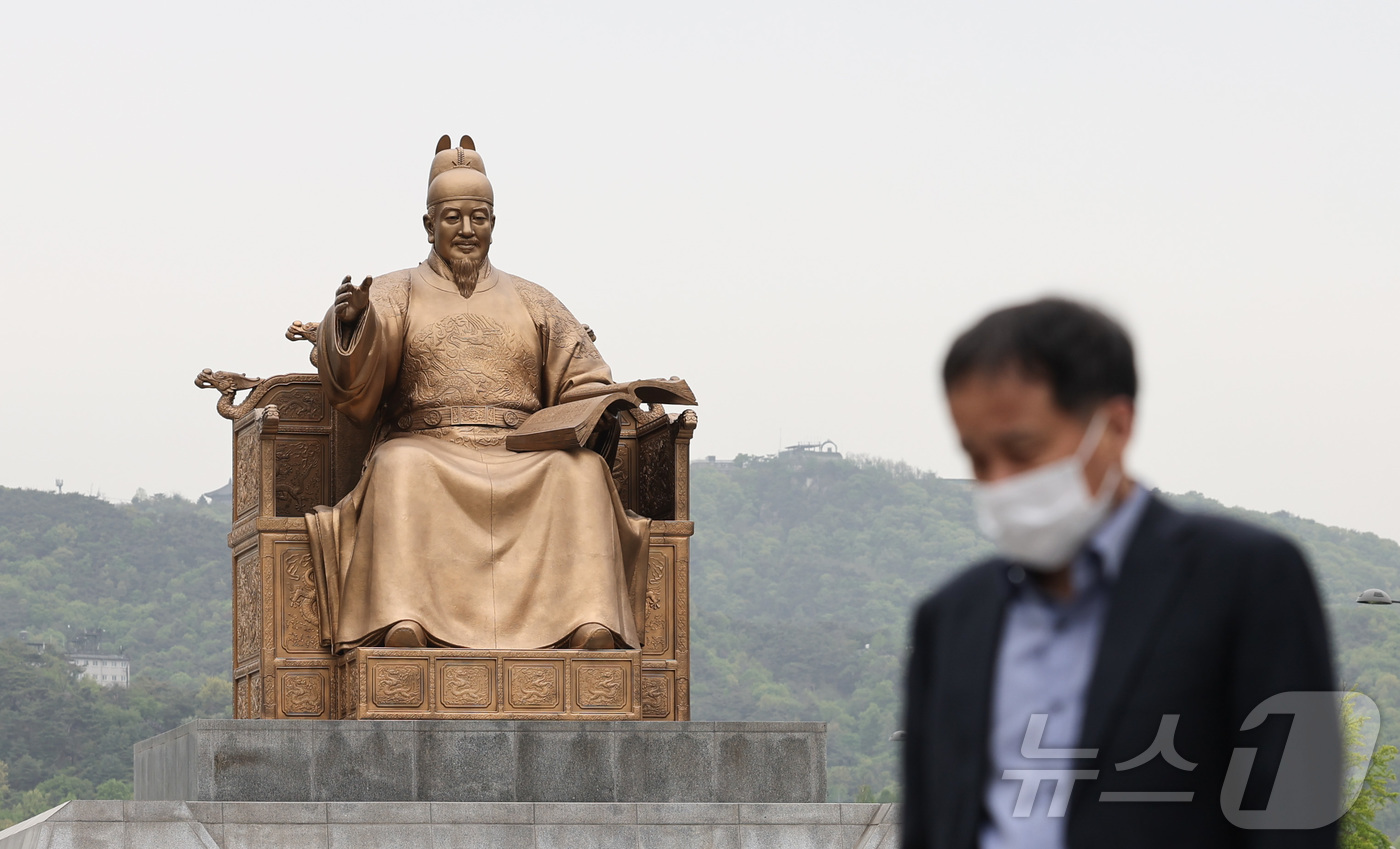 (서울=뉴스1) 이종수 인턴기자 = 잔존 황사의 영향으로 미세먼지가 ‘나쁨’ 수준을 보인 22일 오전 서울 종로구 광화문광장에서 시민이 마스크를 착용한 채 이동하고 있다. 2026 …