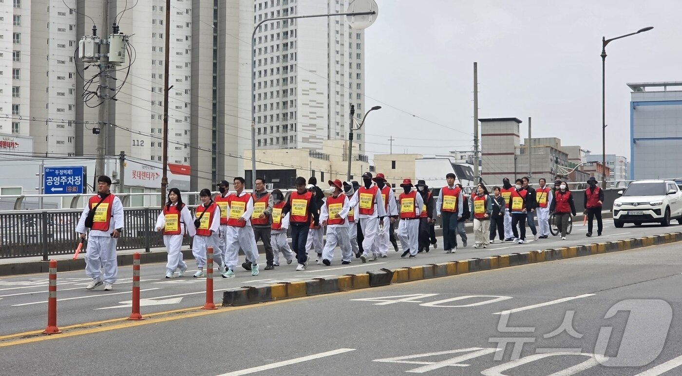 본문 이미지 - 22일 회사의 위장 파산을 주장하며 청와대 도보 행진을 시작한 우창코넥타 직원들이 천안 서북구의 한 도로에서 행진하고 있다. 이들은 일주일간 행진을 계속해 오는 28일 청와대에 도착할 예정이다. ⓒ 뉴스1 이시우 기자