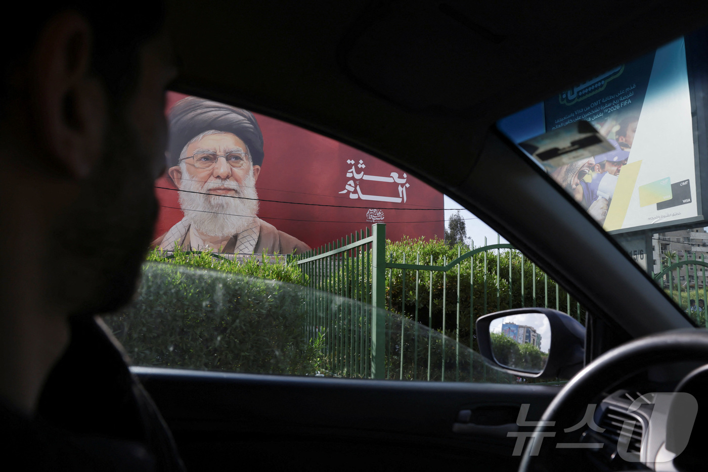 (베이루트 로이터=뉴스1) 김경민 기자 = 고(故) 아야톨라 알리 하메네이 이란 최고지도자의 포스터가 걸린 레바논 베이루트 남부 교외에서 한 남성이 20일(현지시간) 차를 몰고 지 …