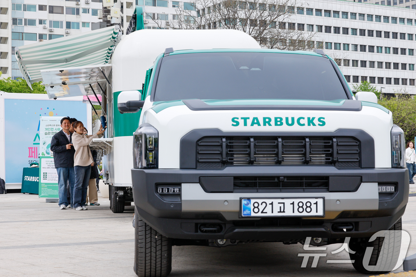 (서울=뉴스1) 안은나 기자 = 스타벅스 코리아가 지구의 날을 맞아 이동형 커피 트레일러 '스:벅차'를 공개한 22일 서울 여의도 한강공원에서 모델들이 개인 컵 지참 고객에게 선착 …