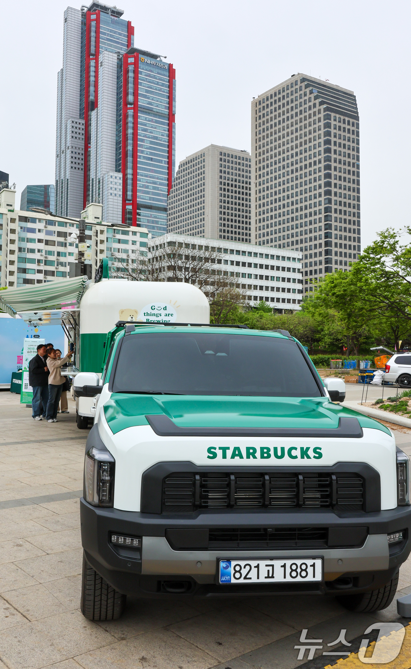 (서울=뉴스1) 안은나 기자 = 스타벅스 코리아가 지구의 날을 맞아 이동형 커피 트레일러 '스:벅차'를 공개한 22일 서울 여의도 한강공원에서 모델들이 개인 컵 지참 고객에게 선착 …