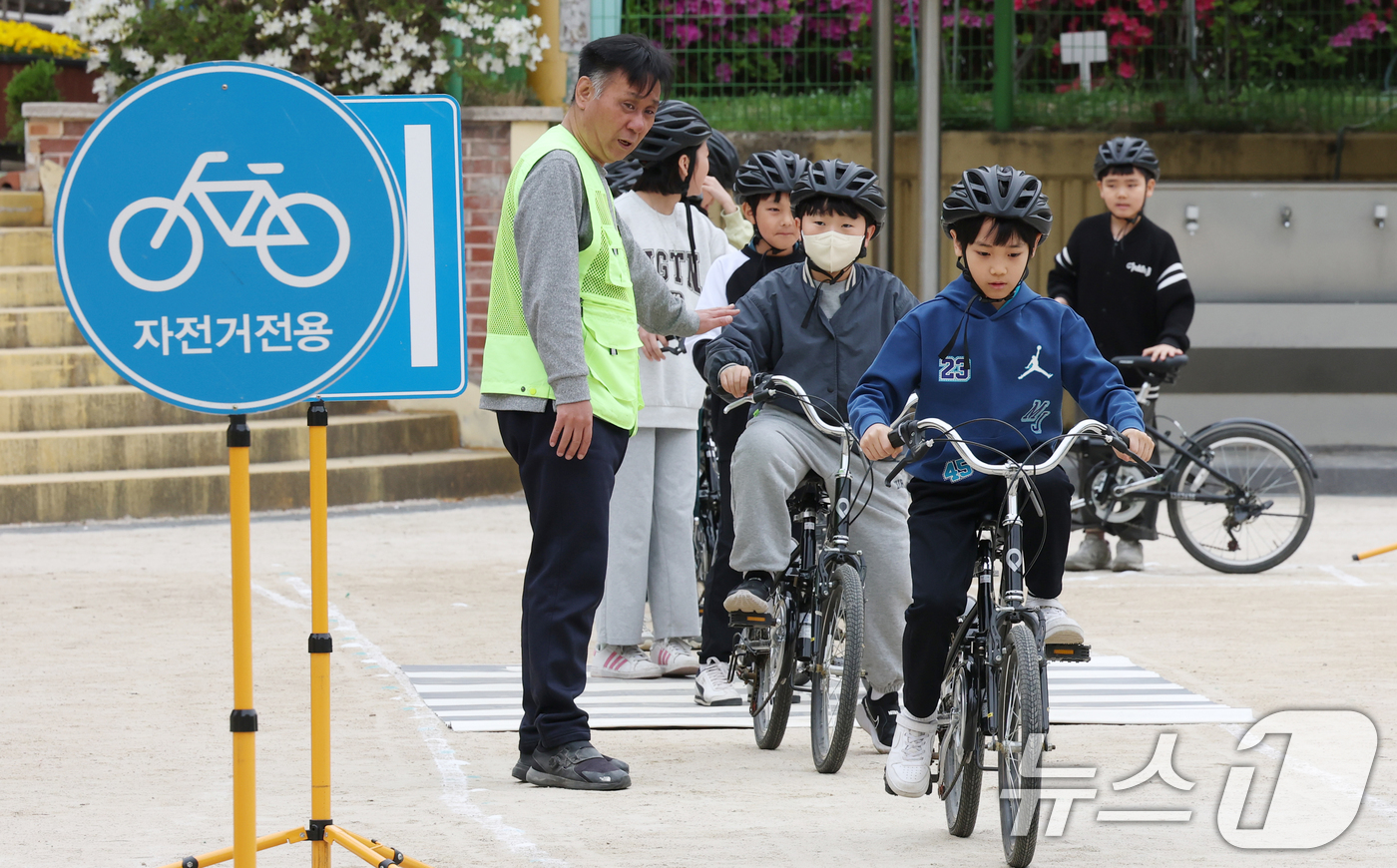 (수원=뉴스1) 김영운 기자 = 자전거의 날인 22일 경기 수원시 권선구 명당초등학교에서 열린 '2026년 찾아가는 자전거&PM(개인형 이동장치) 안전교육'에서 학생들이 교통표지판 …