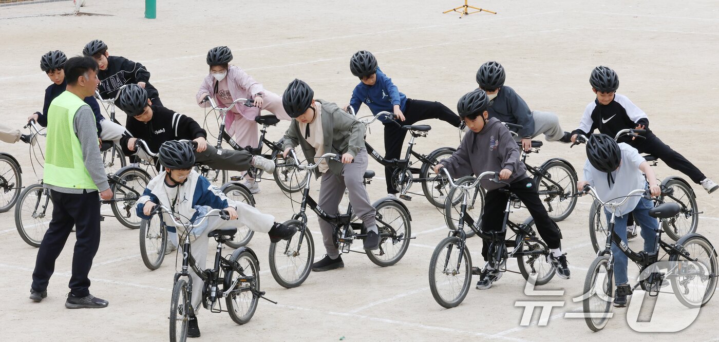 본문 이미지 - 자전거의 날인 22일 경기 수원시 권선구 명당초등학교에서 열린 '2026년 찾아가는 자전거&PM(개인형 이동장치) 안전교육'에서 학생들이 교통표지판과 법규 등 안전 주행 방법을 '자전거와환경 사회적협동조합' 관계자들에게 교육받고 있다. 2026.4.22 ⓒ 뉴스1 김영운 기자