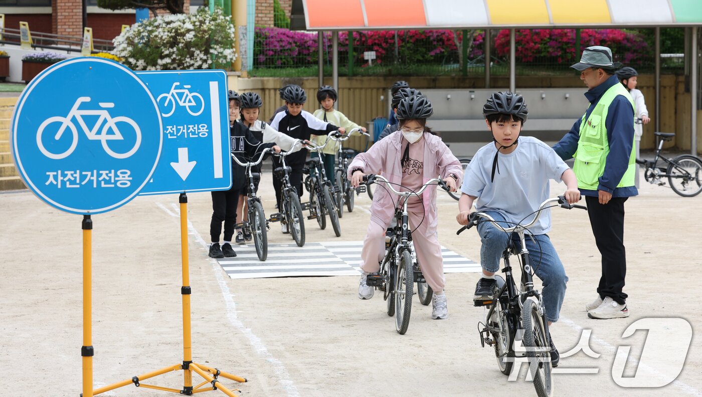본문 이미지 - 자전거의 날인 22일 경기 수원시 권선구 명당초등학교에서 열린 '2026년 찾아가는 자전거&PM(개인형 이동장치) 안전교육'에서 학생들이 교통표지판과 법규 등 안전 주행 방법을 '자전거와환경 사회적협동조합' 관계자들에게 교육받고 있다. 2026.4.22 ⓒ 뉴스1 김영운 기자