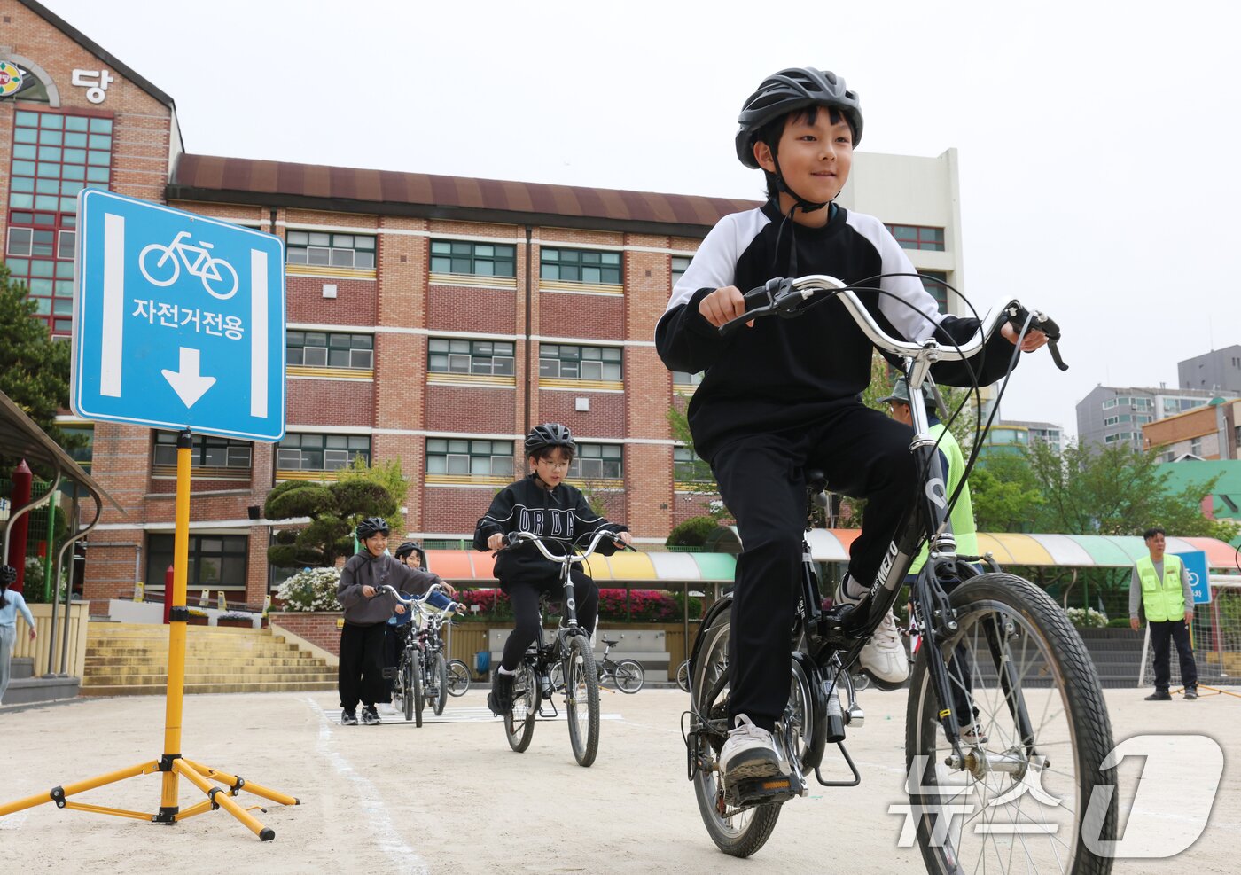 본문 이미지 - 자전거의 날인 22일 경기 수원시 권선구 명당초등학교에서 열린 '2026년 찾아가는 자전거&PM(개인형 이동장치) 안전교육'에서 학생들이 교통표지판과 법규 등 안전 주행 방법을 '자전거와환경 사회적협동조합' 관계자들에게 교육받고 있다. 2026.4.22 ⓒ 뉴스1 김영운 기자
