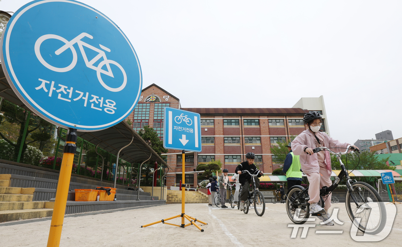 (수원=뉴스1) 김영운 기자 = 자전거의 날인 22일 경기 수원시 권선구 명당초등학교에서 열린 '2026년 찾아가는 자전거&PM(개인형 이동장치) 안전교육'에서 학생들이 교통표지판 …