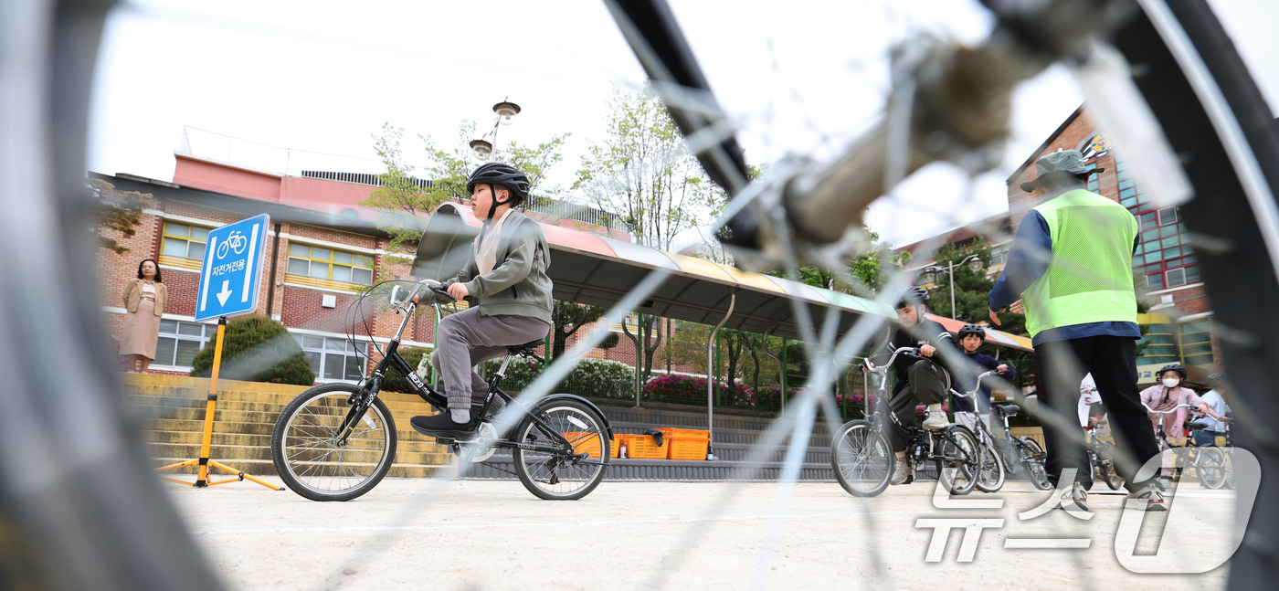 (수원=뉴스1) 김영운 기자 = 자전거의 날인 22일 경기 수원시 권선구 명당초등학교에서 열린 '2026년 찾아가는 자전거&PM(개인형 이동장치) 안전교육'에서 학생들이 교통표지판 …