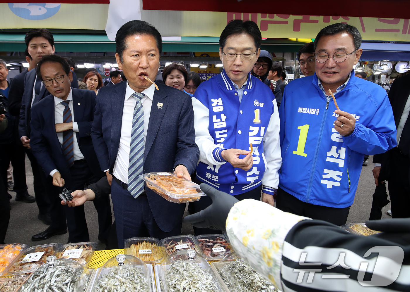 (통영=뉴스1) 윤일지 기자 = 정청래 더불어민주당 대표가 22일 경남 통영 통영중앙전통시장을 찾아 김경수 경남도지사 후보, 강석주 통영시장 후보와 함께 오징어를 맛보고 있다. 2 …