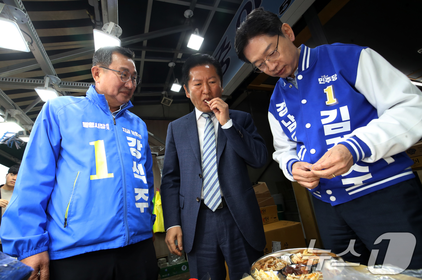 (통영=뉴스1) 윤일지 기자 = 정청래 더불어민주당 대표가 22일 경남 통영 통영중앙전통시장을 찾아 김경수 경남도지사 후보, 강석주 통영시장 후보와 함께 건어물을 맛보고 있다. 2 …