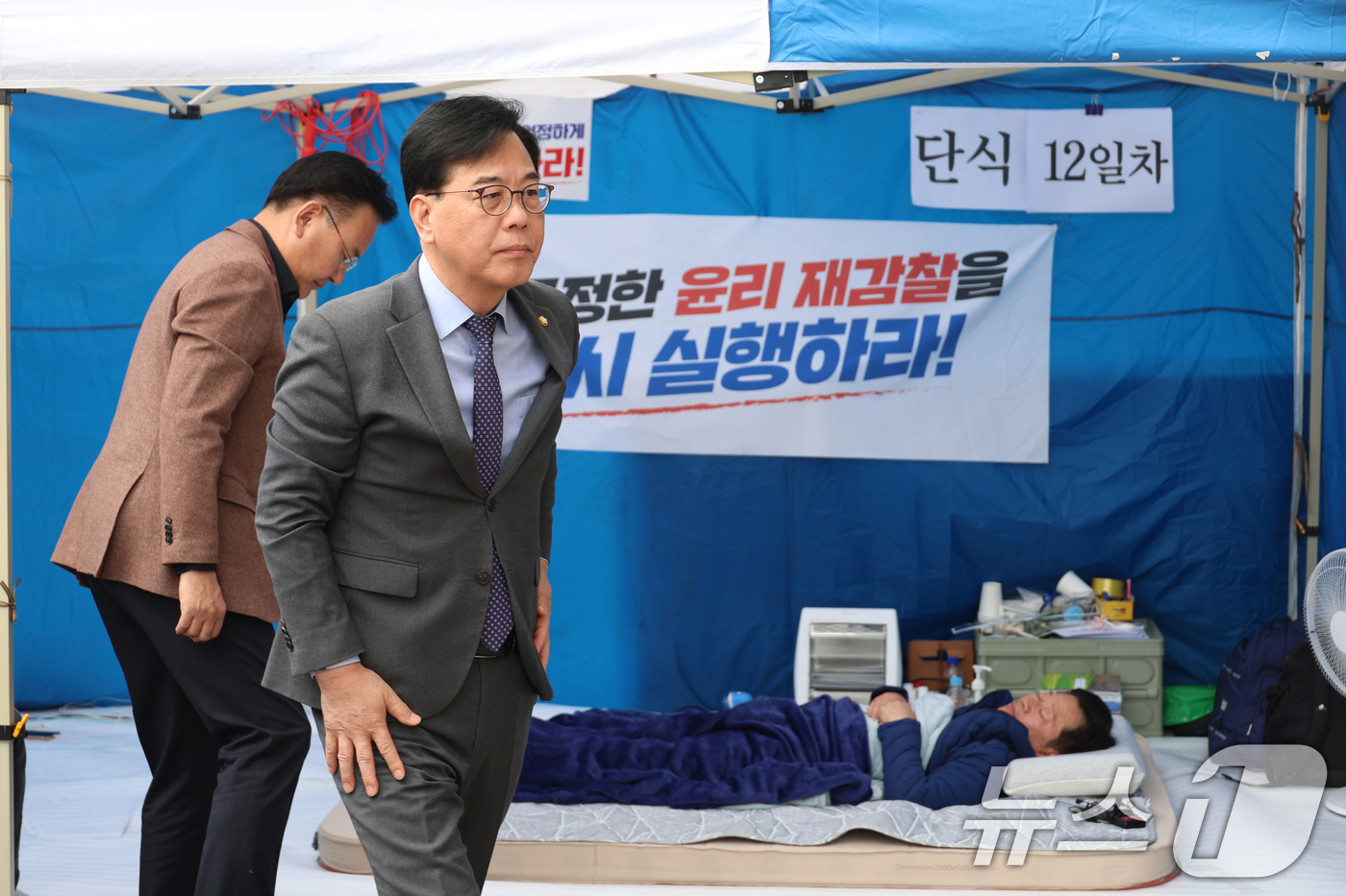 (서울=뉴스1) 신웅수 기자 = 송언석 국민의힘 원내대표가 22일 서울 여의도 국회 앞 천막에서 단식농성 중인 안호영 더불어민주당 의원을 찾아 대화 후 천막을 나서고 있다. (공동 …