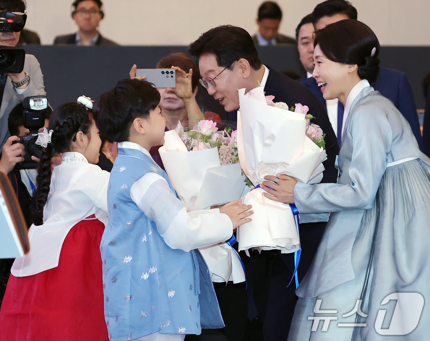 (하노이(베트남)=뉴스1) 이재명 기자 = 베트남을 국빈 방문 중인 이재명 대통령과 김혜경 여사가 22일(현지시간) 하노이의 한 호텔에서 열린 동포 오찬 간담회에서 화동에게 꽃다발 …