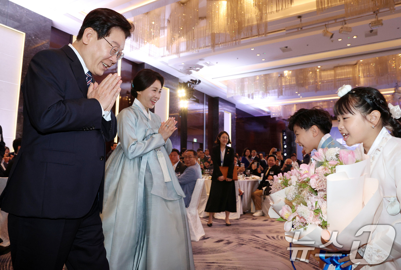 (하노이(베트남)=뉴스1) 이재명 기자 = 베트남을 국빈 방문 중인 이재명 대통령과 김혜경 여사가 22일(현지시간) 하노이의 한 호텔에서 열린 동포 오찬 간담회에서 화동에게 꽃다발 …